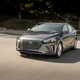 Gray hybrid hatchback careens wildly down residential street.